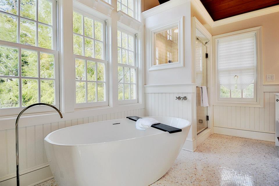 Bright bathroom with soaking tub and glass tiled shower